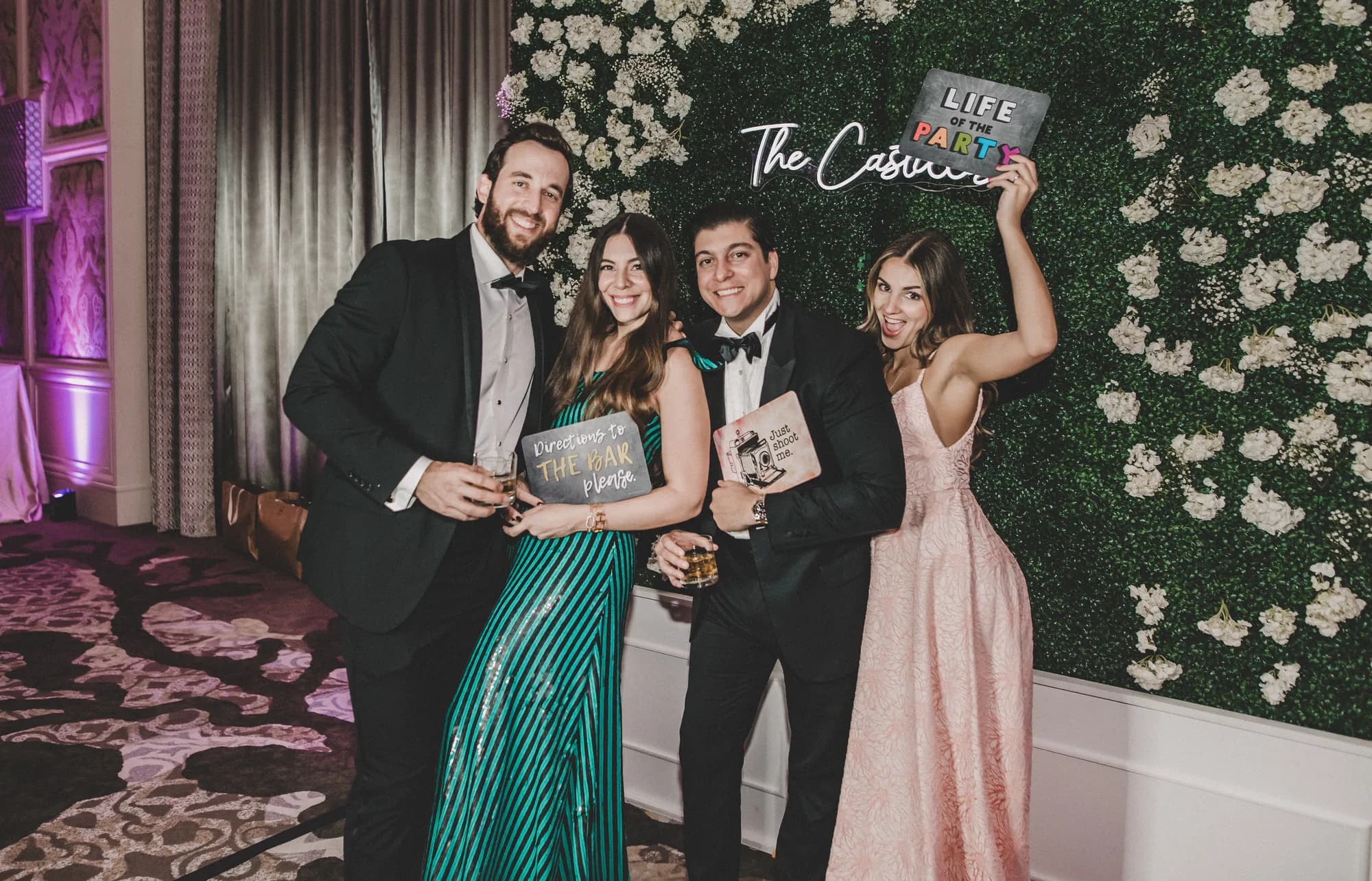Bride and groom at an iRock Your Party photo booth with a white flower wall backdrop